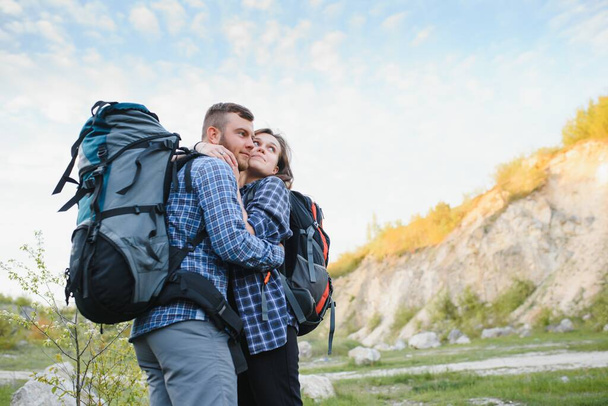 Ευτυχισμένο ρομαντικό ζευγάρι Άντρας και γυναίκα Ταξιδιώτες με σακίδιο που κρατά τα χέρια ορειβασία Ταξίδι Lifestyle και σχέση αγάπη έννοια βουνά τοπίο στο παρασκήνιο - Φωτογραφία, εικόνα
