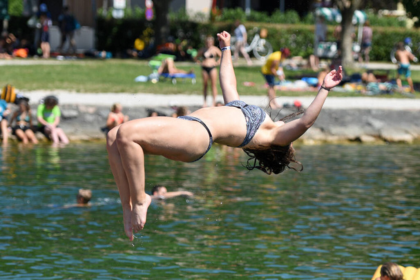 Springen, zwemmen en zwemmen - Zwemmen en zwemmen is ontspannen, genieten en afkoelen bij warme temperaturen (Salzkammergut, Opper-Oostenrijk)). - Foto, afbeelding