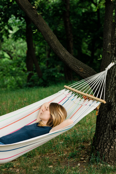 Young woman relaxing in the hammock in nature - Foto, Imagen