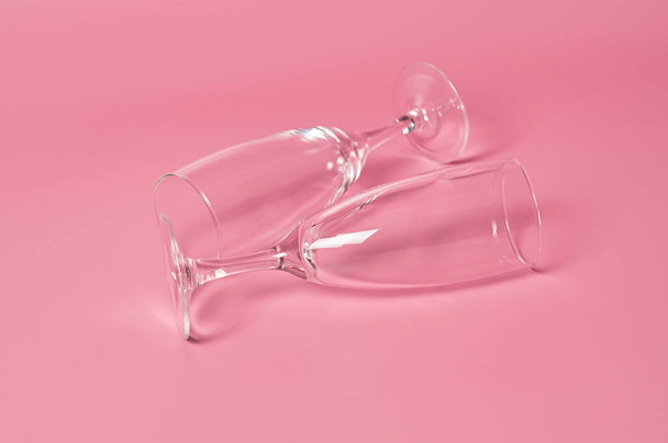 Two glasses for champagne lies on pink table on kitchen. Concept of celebrating. Close-up - Foto, Imagem