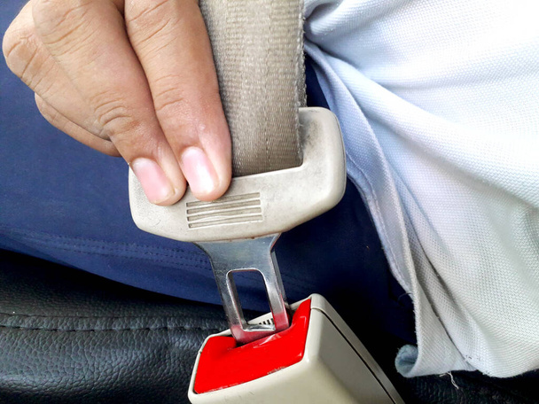 Eine männliche Person, die Sicherheitsgurt trägt, indem sie ihn während der Fahrt abschaltet, kennt Fahrregeln und ist daher bei einem Unfall sicher - Foto, Bild