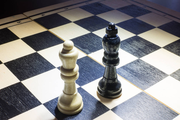 Siyah kral ve beyaz kraliçenin kavrayış içinde olduğu satranç tahtası - Fotoğraf, Görsel