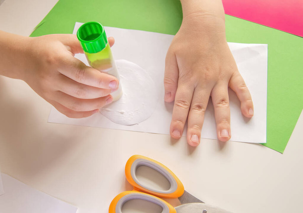 ステップ3 。子供は接着剤を使う。DIYと子供の創造性の概念。ステップバイステップの手順:どのように紙からパンダのアプリケーションを作成します。隔離中の児童との創作活動. - 写真・画像