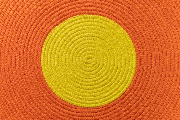 中央に黄色の円を持つ手作りのラウンドオレンジ綿のニットラグの画像,上部ビュー,直接上記. - 写真・画像