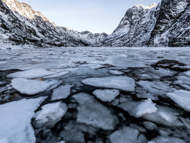 Winter landscape on a lake during Lofoten islands winter. Snow and ice melting  - Photo, image