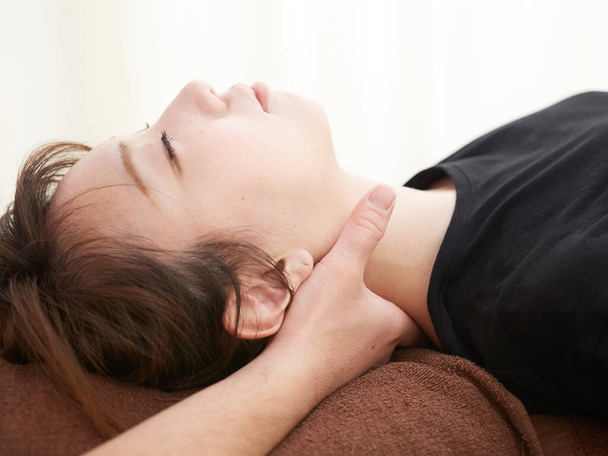 A Japanese woman getting a neck massage - Foto, Imagen