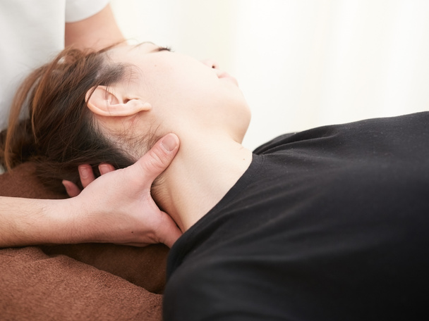 A Japanese woman getting a neck massage - Foto, afbeelding