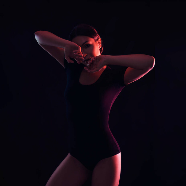 Portrait of a woman body in colorful dark light on a black background. neon imitation. - 写真・画像