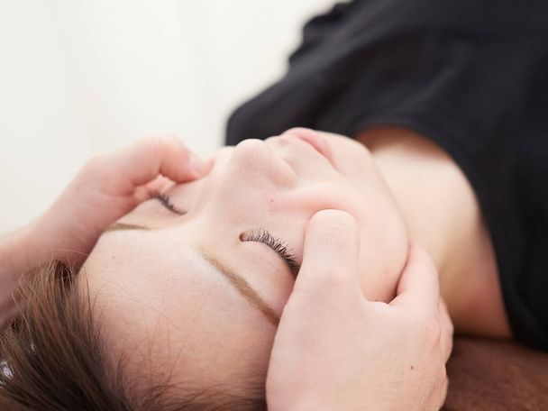 A Japanese woman getting a cheekbone massage - Foto, Imagem