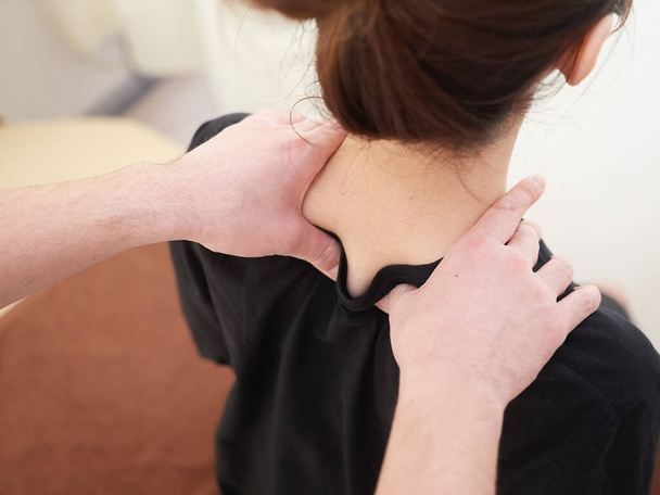 Una mujer japonesa recibiendo un masaje en el hombro
 - Foto, Imagen