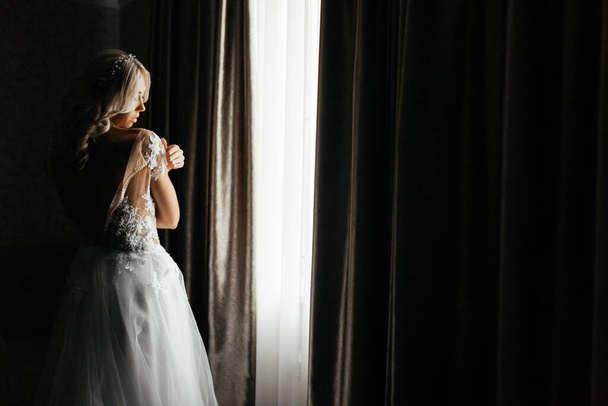 Novia en el vestido de novia tocando su hombro
 - Foto, Imagen