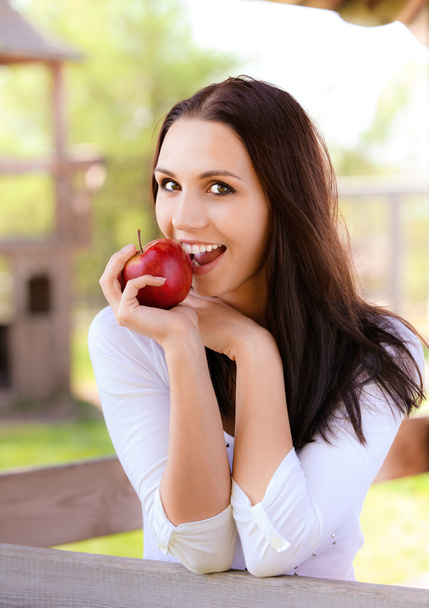 Young woman bites apple - Zdjęcie, obraz