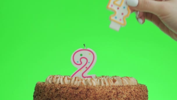 Het zetten van een nummer vierentwintig verjaardag kaars op een heerlijke taart, groen scherm 24 - Video