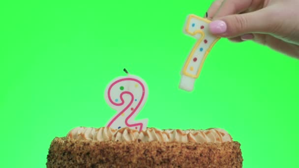 Βάζοντας ένα κερί αριθμό είκοσι επτά γενεθλίων σε ένα νόστιμο κέικ, πράσινη οθόνη 27 - Πλάνα, βίντεο