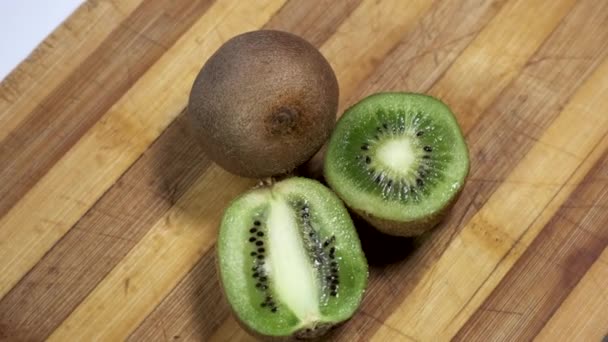 Kiwi-Frucht auf Holztisch halbieren. - Filmmaterial, Video