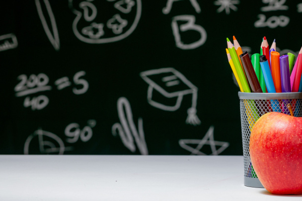 Back to school background with books, pencils and apple on white table - 写真・画像