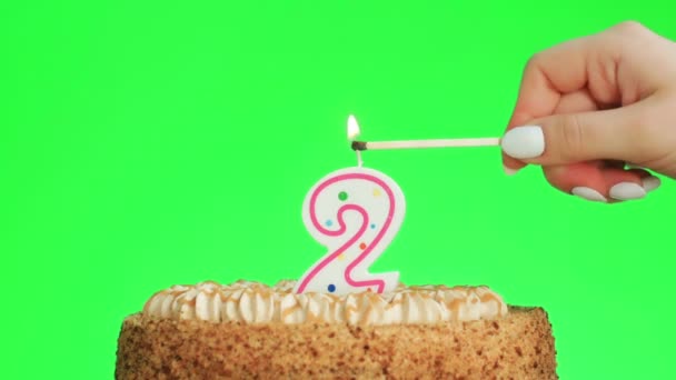 Zapalenie numer dwa świeczka urodzinowa na pyszne ciasto, zielony ekran 2 - Materiał filmowy, wideo