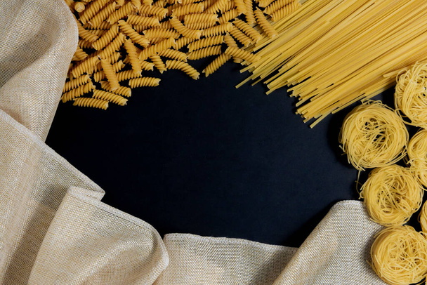 Assortment of different types of pasta dry on black background - Foto, imagen