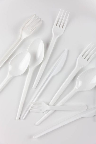 Plastic items. White plastic eating utensils. For the presentation of waste recycling. Disposable tableware - Foto, immagini