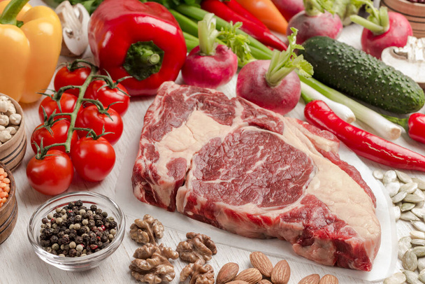 野菜、豆、白を背景にナッツとマーブルドビーフステーキ。タンパク質の天然源。トップ表示 - 写真・画像