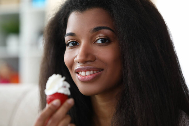 Dark-skinned girl holds strawberries with cream - Foto, Imagen