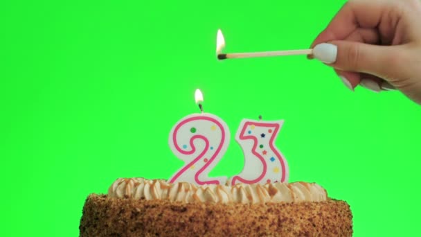 Zapalenie numeru dwadzieścia trzy świeczki urodzinowej na pyszne ciasto, zielony ekran 23 - Materiał filmowy, wideo