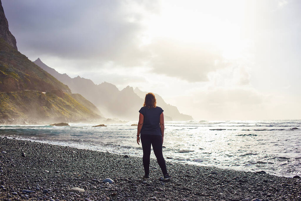Woman standing on black sand volcanic Beniho (Benijo) Beach - North part of Tenerife. Canary Islands. Spain - Fotografie, Obrázek