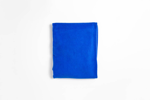 Modrý skládaný ručník izolovaný na bílém pozadí. Koupelny.Fotografie s vysokým rozlišením. Perspektiva. - Fotografie, Obrázek