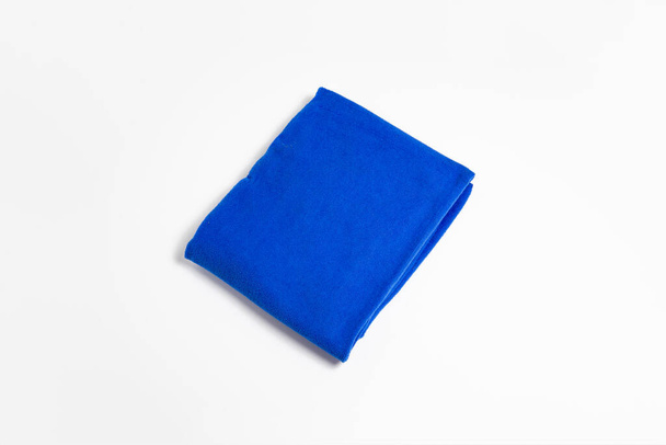 Blaues gefaltetes Handtuch isoliert auf weißem Hintergrund. Badehandtuch.Hochauflösendes Foto.Perspektivische Ansicht. - Foto, Bild