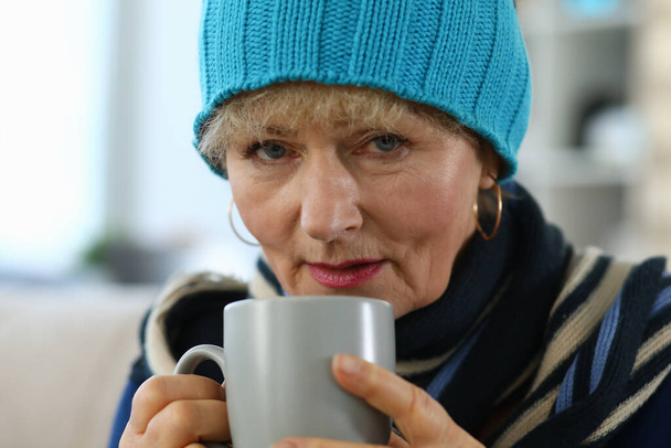 Mulher idosa se sente doente e bebe chá em casa
 - Foto, Imagem