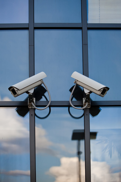 Deux caméras de sécurité attachées sur le bâtiment d'affaires avec reflecti
 - Photo, image