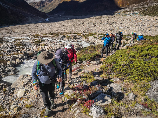 A group of tourists walks along a mountain trail in the Himalayas - Photo, Image