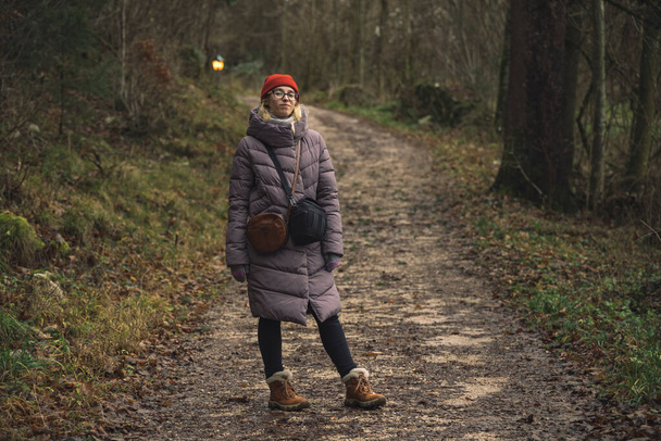 női portré séta ideje késő őszi szezonban idő erdő természet hangulatos környezet tér elmosódott háttér és szabadtéri lámpás világítás - Fotó, kép