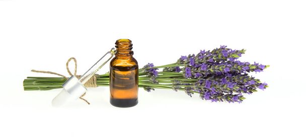 Essential lavender oil in the bottle with dropper isolated on white background. Horizontal close-up - Photo, Image