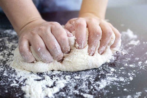 Close up of hands kneading dough for bread, pasta or pizza - Foto, Imagen