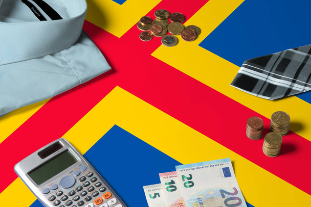 Aland Islands flag on minimal money concept table. Coins and financial objects on flag surface. National economy theme. - Foto, imagen