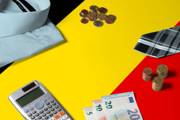 Belgium flag on minimal money concept table. Coins and financial objects on flag surface. National economy theme. - Fotó, kép