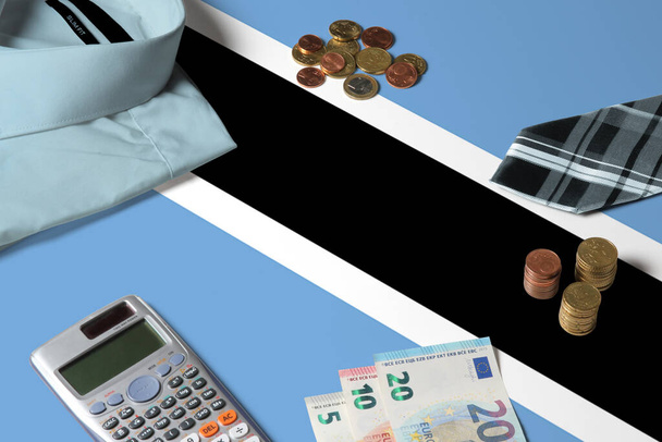 Botswana flag on minimal money concept table. Coins and financial objects on flag surface. National economy theme. - Fotografie, Obrázek