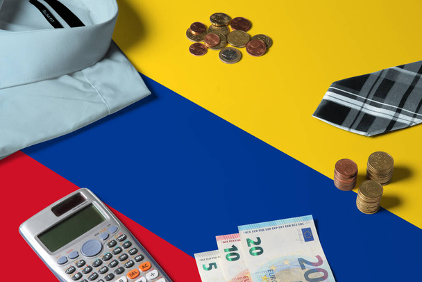 Colombia flag on minimal money concept table. Coins and financial objects on flag surface. National economy theme. - Fotografie, Obrázek