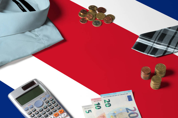 Costa Rica flag on minimal money concept table. Coins and financial objects on flag surface. National economy theme. - 写真・画像