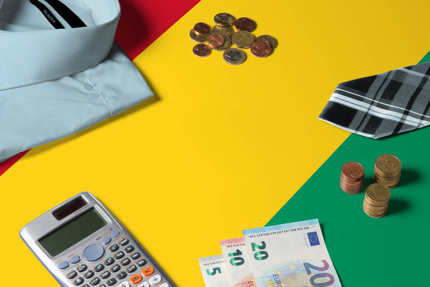 Guinea Bissau vlajka na minimálním koncipovacím stole. Mince a finanční objekty na povrchu vlajky. Téma národního hospodářství. - Fotografie, Obrázek