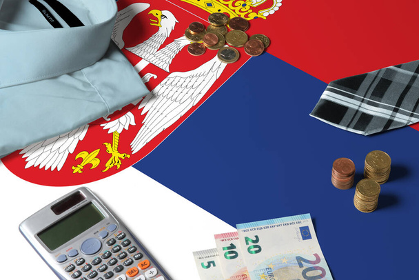 Serbia flag on minimal money concept table. Coins and financial objects on flag surface. National economy theme. - Fotografie, Obrázek