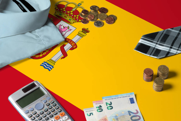 Spain flag on minimal money concept table. Coins and financial objects on flag surface. National economy theme. - Фото, изображение