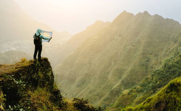 Человек с картой пребывания на вершине горной породы с великолепным панорамным видом на высокие горные хребты и глубокую долину
 - Фото, изображение