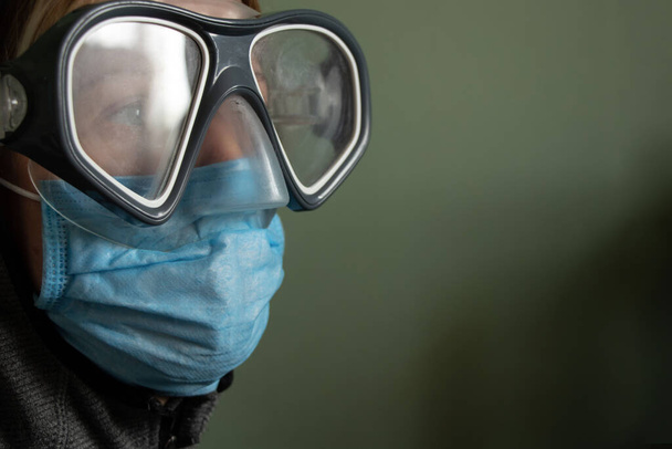 menina em uma máscara médica e óculos de segurança sozinho
 - Foto, Imagem