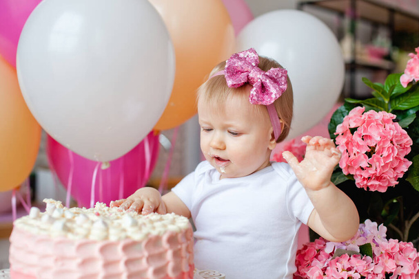 pieni tyttö pöydällä syntymäpäiväkakun ja ilmapallojen kanssa
 - Valokuva, kuva