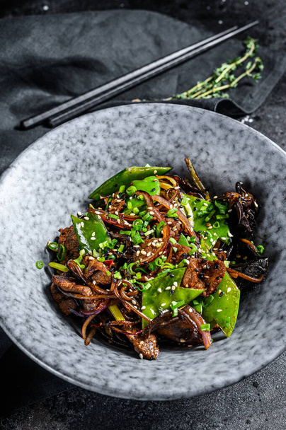 Soba noodles with beef, carrots, onions and sweet peppers. Stir fry wok. Black background. Top view. - Foto, Bild