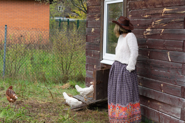 a village girl stands in a village near chickens - Φωτογραφία, εικόνα