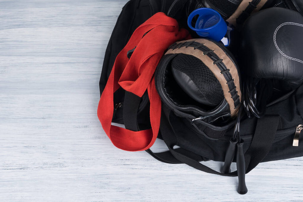 saco de esportes preto com coisas para treinamento em um fundo leve
 - Foto, Imagem