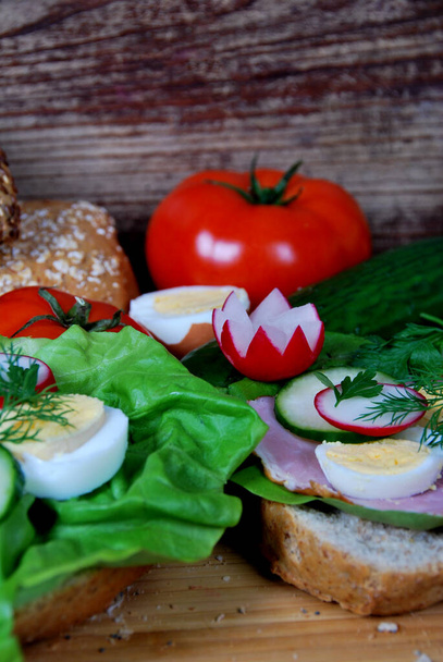 sandwich with lettuce, ham and boiled egg rings, radish and dill - Foto, Imagem
